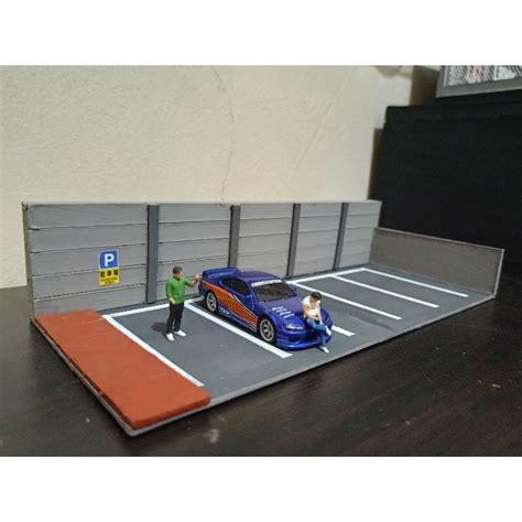 A parking lot diorama with detailed vehicles and scenery